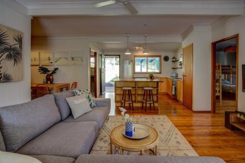 una sala de estar con un sofá y una mesa en Macs Beach Bungalow, en Macmasters Beach