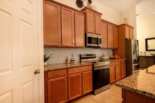 a kitchen with wooden cabinets and a stove top oven at Serenity Escape in Palm Coast