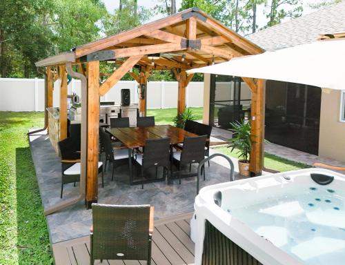 a patio with a table and a hot tub at Serenity Escape in Palm Coast