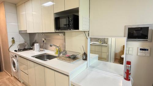 a small kitchen with a sink and a refrigerator at Kozy House in Gangnam in Seoul
