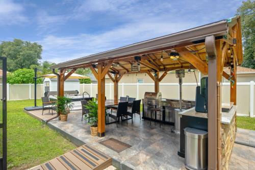 a pavilion with a grill and tables and chairs at Serenity Escape in Palm Coast