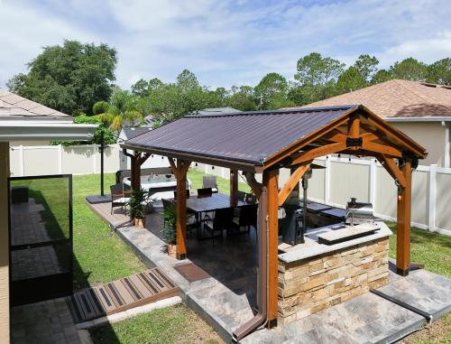 a wooden gazebo with a table in a backyard at Serenity Escape in Palm Coast