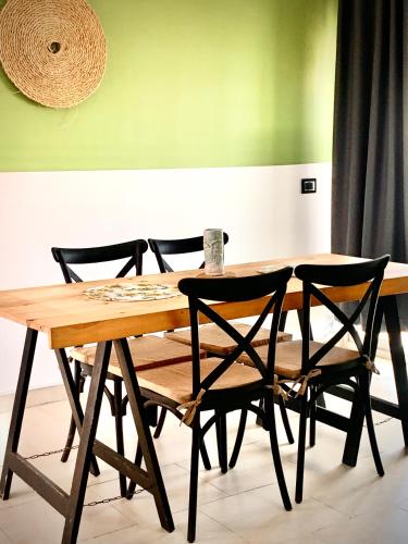 a wooden table with four chairs around it at Havre de paix au centre de la marsa in La Marsa