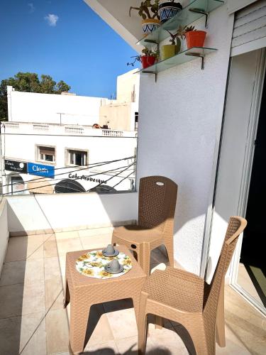 a pair of chairs and a table on a balcony at Havre de paix au centre de la marsa in La Marsa