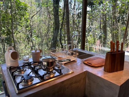 a kitchen with a stove and a window with trees at Casa Aquário in Petrópolis