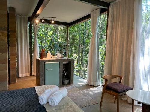 a bedroom with a bed and a table and a window at Casa Aquário in Petrópolis
