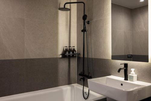 a bathroom with a tub and a sink and a shower at Mitasuya Ryokan Hotel by Aank Cheonan in Cheonan