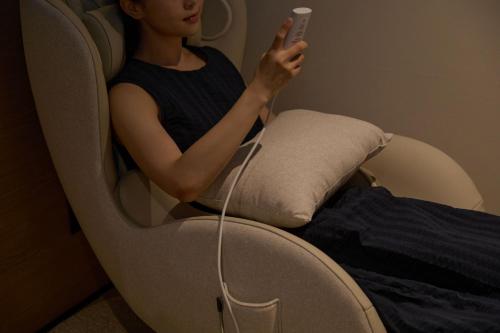 a woman sitting in a chair holding a wii remote at Mitasuya Ryokan Hotel by Aank Cheonan in Cheonan