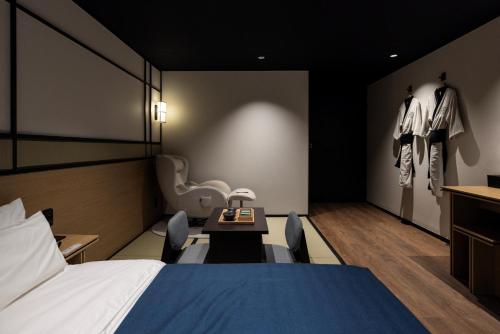 a bedroom with a bed and a table with chairs at Mitasuya Ryokan Hotel by Aank Cheonan in Cheonan