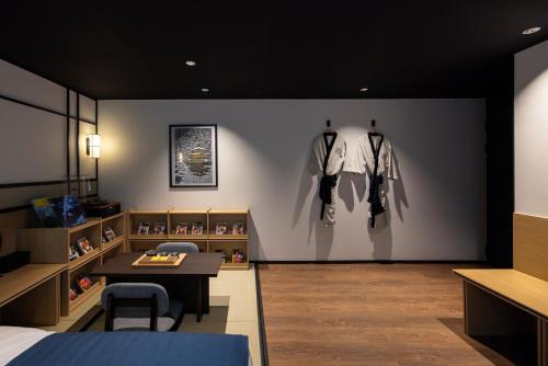 a room with a bed and a wall with clothes on display at Mitasuya Ryokan Hotel by Aank Cheonan in Cheonan