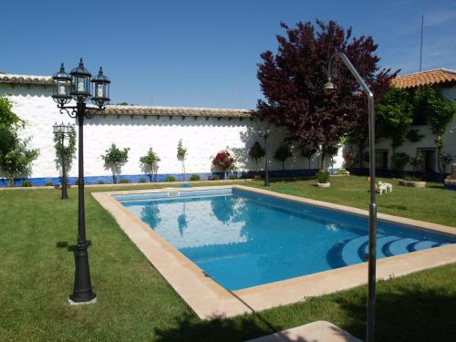 a swimming pool in a yard next to a building at Casa Rural El Arriero in Los Hinojosos