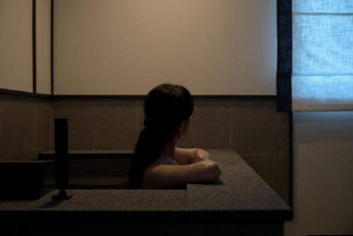 a girl sitting in a bath tub in a room at Mitasuya Ryokan Hotel by Aank Cheonan in Cheonan