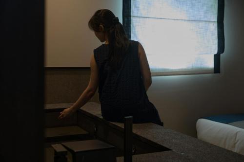 a woman walking up the stairs in a room at Mitasuya Ryokan Hotel by Aank Cheonan in Cheonan