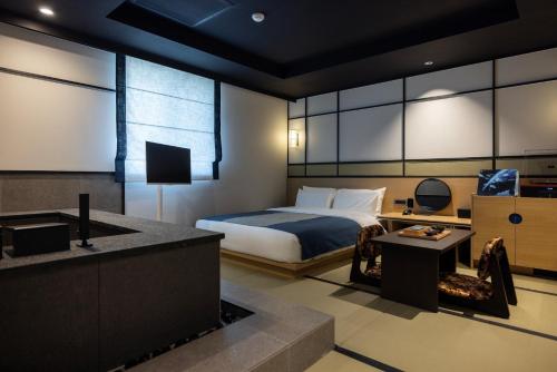 a hotel room with a bed and a television at Mitasuya Ryokan Hotel by Aank Cheonan in Cheonan