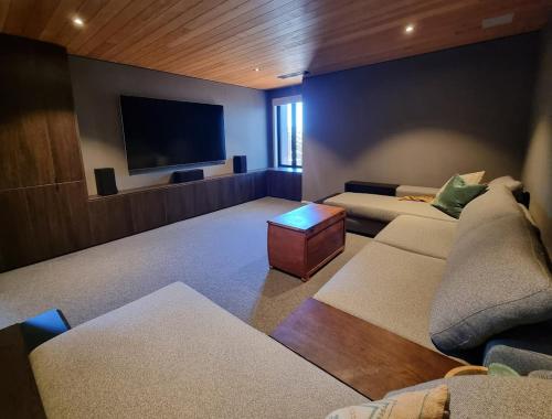 ニュープリマスにあるLuxury Fitzroy Beach Retreatのソファ2脚と薄型テレビのあるリビングルーム