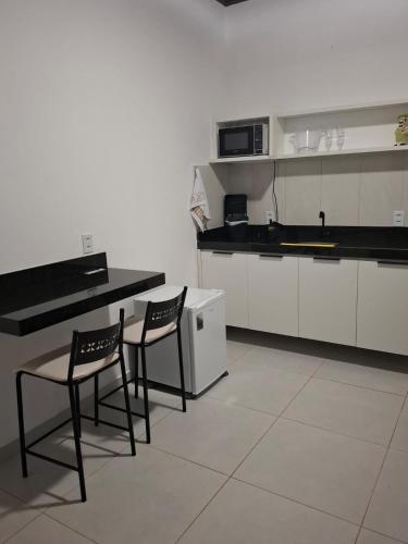 a kitchen with two chairs and a table in it at Pousada Chalés da Serra in Cuité