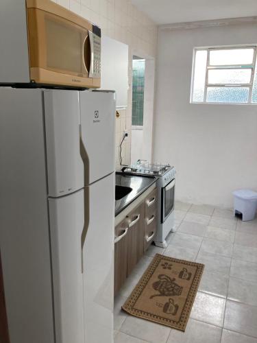 a kitchen with a white refrigerator and a stove at Apartamento aconchegante in Rio Grande