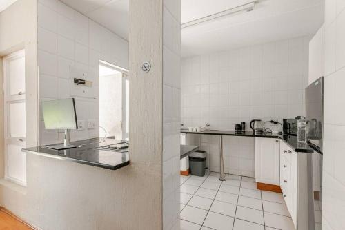 cocina con encimera y paredes de azulejos blancos en Peaceful & Cozy Apartment, en Johannesburgo