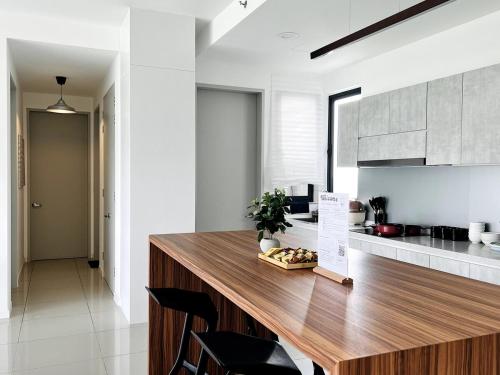 a kitchen with a wooden counter top in a room at NEW Designer Condo - Panoramic Forest View - Steps To IOI City Mall - Your Best Urban Retreat in Putrajaya