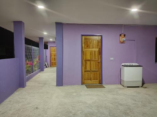 a room with purple walls and a door at Homestay Impian Bapa in Semporna
