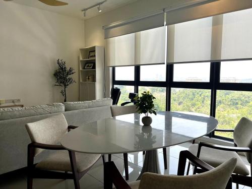 a living room with a table and a couch at NEW Designer Condo - Panoramic Forest View - Steps To IOI City Mall - Your Best Urban Retreat in Putrajaya
