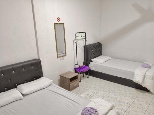 a small room with two beds and a mirror at Homestay Impian Bapa in Semporna