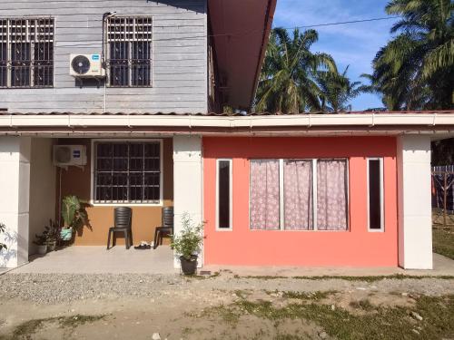 a house with a red door and two chairs at Homestay Impian Bapa in Semporna