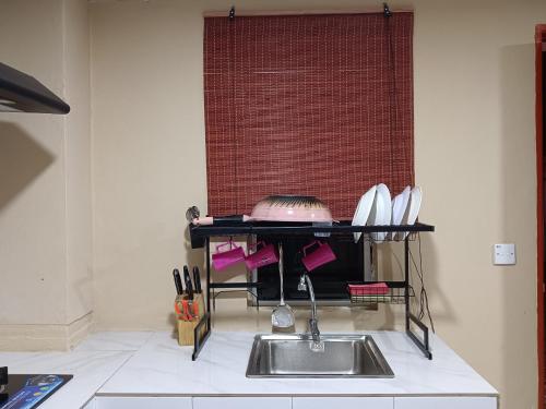 a kitchen with a sink and a counter with utensils at Homestay Impian Bapa in Semporna