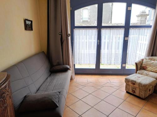 un salon avec un canapé et une grande fenêtre dans l'établissement Ground floor apartment with terrace near the beach, au Pouldu