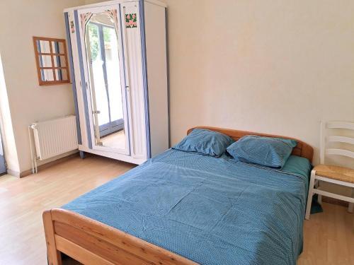 une chambre avec un lit avec des draps bleus et un miroir dans l'établissement Ground floor apartment with terrace near the beach, cleaning included, au Pouldu