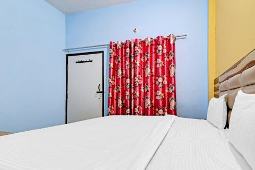 a bedroom with a bed and a red curtain at Hotel O Knight guest house in Morādābād
