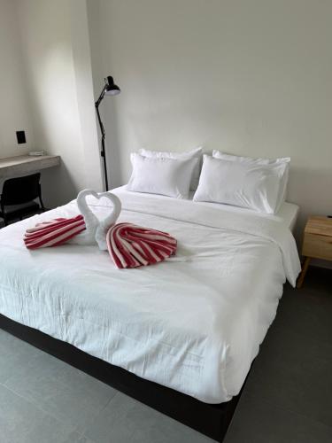 a white bed with two towels in the shape of a heart at JJ and J Garden1 Pai in Pai