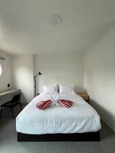 a bedroom with a white bed with red and white pillows at JJ and J Garden1 Pai in Pai