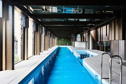 a swimming pool with blue water in a building at Top CBD Skyline Luxury Apartments 2 Beds or 3 Beds, 2 Baths, Free Parking in Melbourne