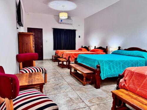a room with four beds and chairs in it at Esquina Lodge in Esquina