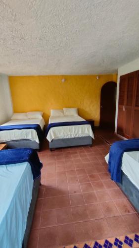 a room with three beds and a tile floor at Finca Villa Tere in Fusagasuga