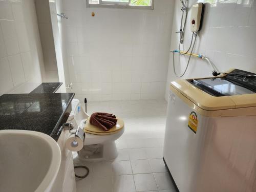 a white bathroom with a sink and a toilet at เอสเอสเฮ้าแอ๊ดอ่าวนาง in Ao Nang 