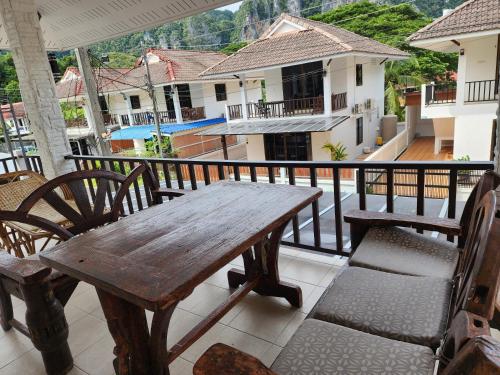 a wooden table and chairs on a balcony at เอสเอสเฮ้าแอ๊ดอ่าวนาง in Ao Nang 