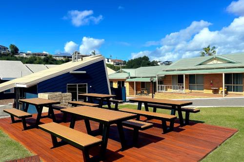 a group of picnic tables and benches on a deck at Waves Geraldton in Geraldton