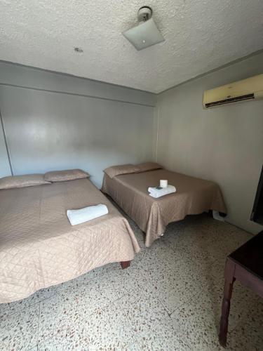 La EntradaにあるHotel Centralのベッド2台とテーブルがある部屋