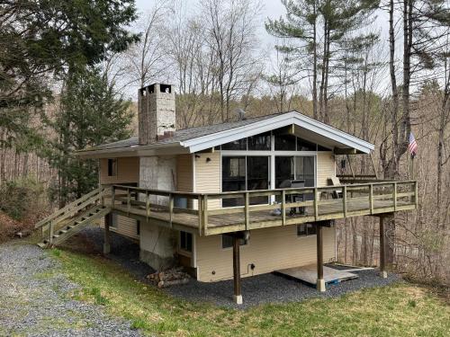 a house with a large deck and a chimney at Cabin on the hill Ascutney 