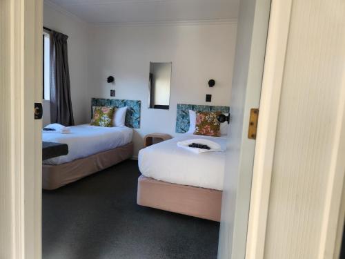 a hotel room with two beds and a couch at Amber Court Motel Nelson in Nelson