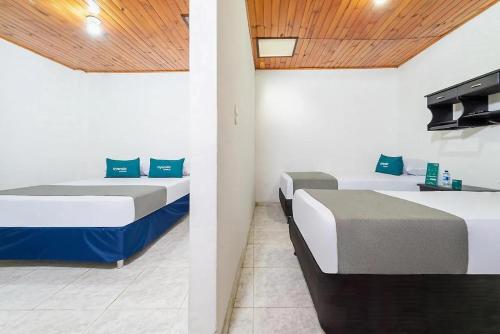 two beds in a room with twothirdsessions at Hotel Marlon in Villavicencio
