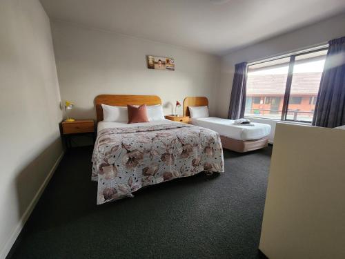 a hotel room with a bed and a window at Amber Court Motel Nelson in Nelson