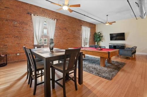 a dining room with a ping pong table and a brick wall at Top Floor Loft in Downtown Indianapolis in Indianapolis