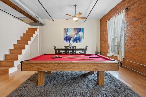 a ping pong table in a room with a brick wall at Top Floor Loft in Downtown Indianapolis in Indianapolis