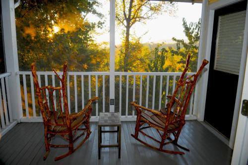 two rocking chairs on a porch with a view at Orchard Inn in Saluda