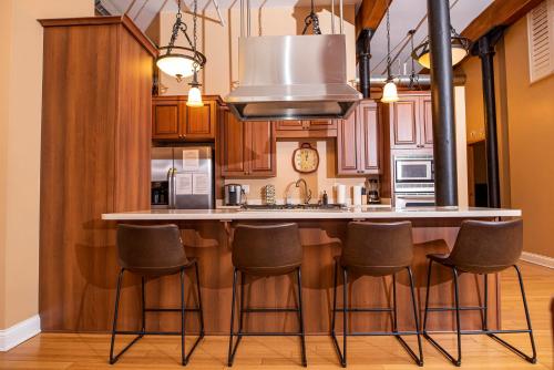 a kitchen with a bar with stools in it at Luxurious Downtown Condo by Georgia St in Indianapolis