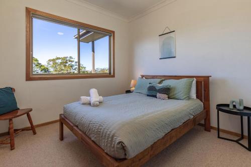a bedroom with a bed with a teddy bear on it at Follow The Sun in Smiths Lake