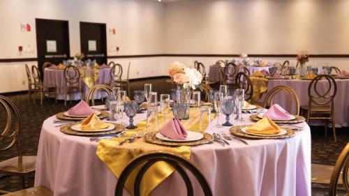 a table set up for a wedding with pink and yellow napkins at Holiday Inn Orizaba by IHG in Orizaba